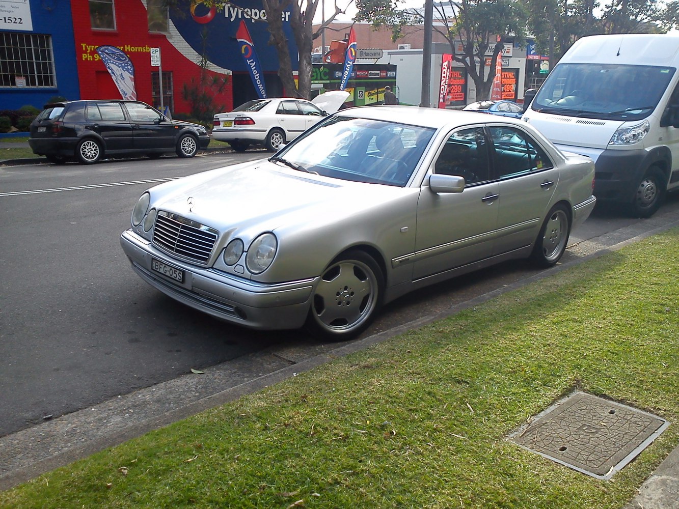Silver sedan with oval headlights and prominent grille.