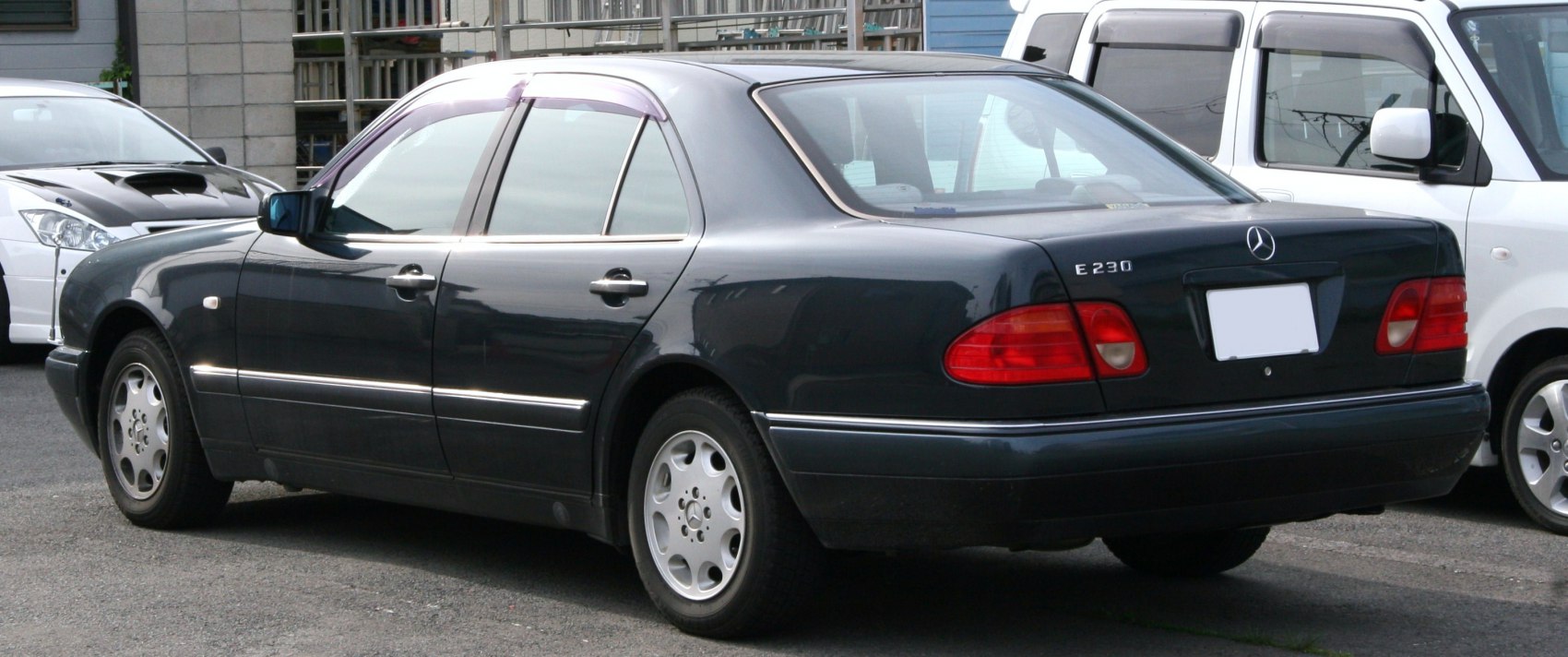 Rear and side profile of sedan with oval tail lights and alloy wheels