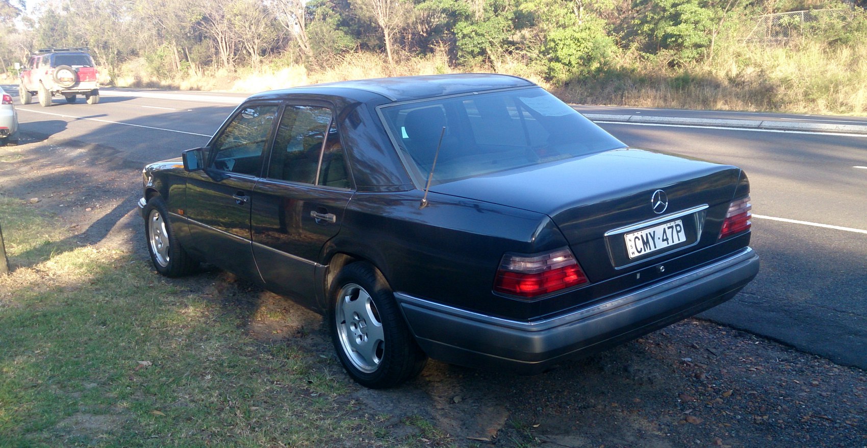 Rear and side view of a sedan showing taillights, alloy wheels, and rear antenna.