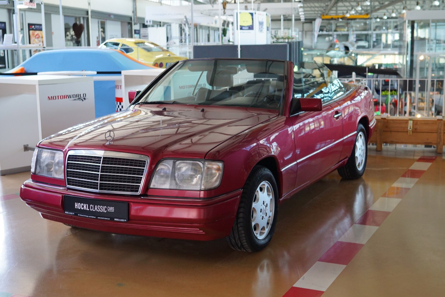 Red convertible with chrome grille and white alloy wheels