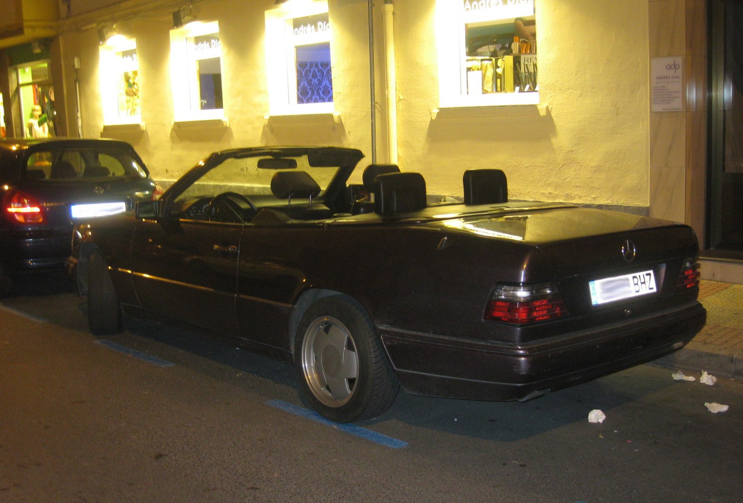 Rear side view of a classic convertible with open top at night