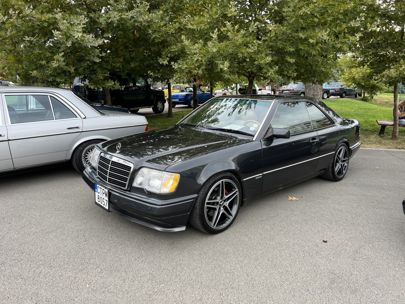 Black coupe with alloy wheels, front and side view, outdoor setting