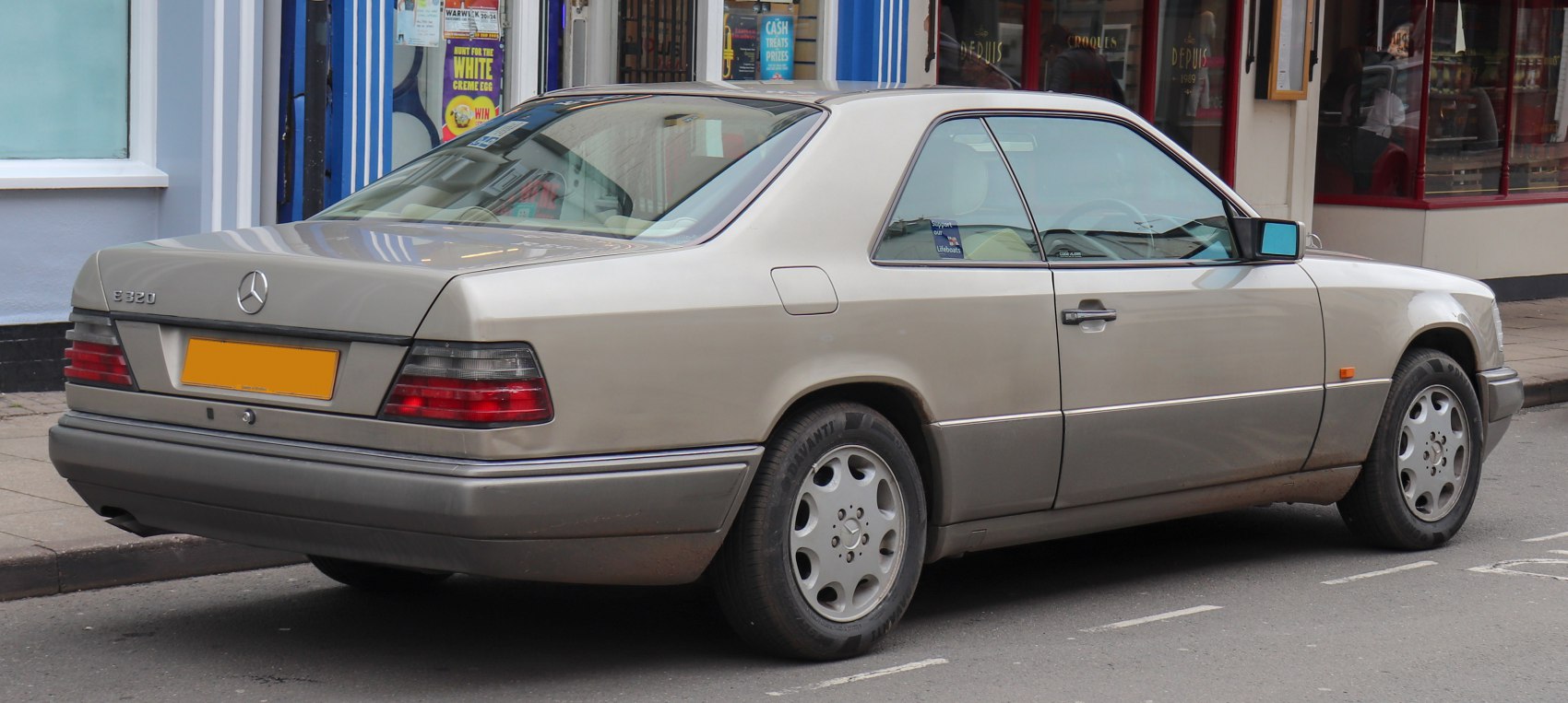 Rear side view of a classic 1990s coupe with distinctive taillights and alloy wheels