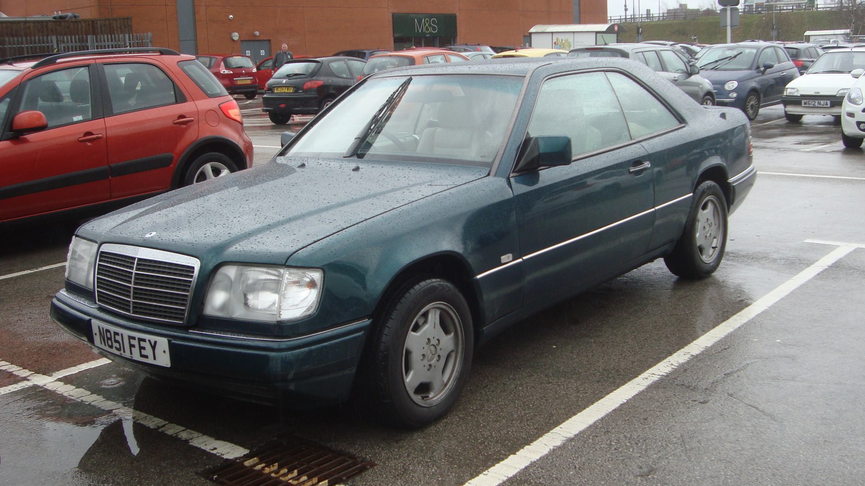 Vintage coupe with rain droplets on exterior and distinctive alloy wheels