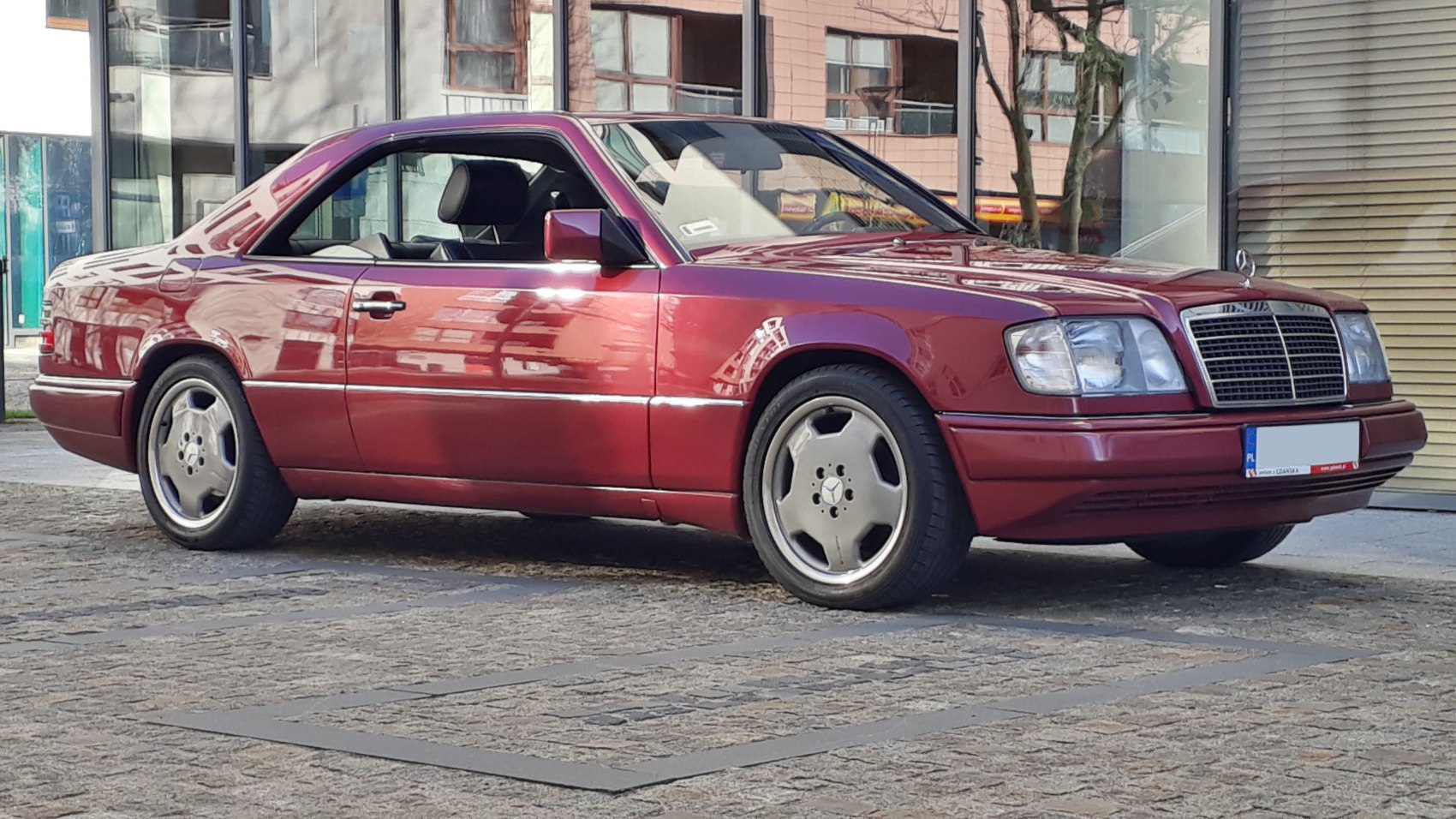 Red two-door coupe with distinctive alloy wheels and classic lines