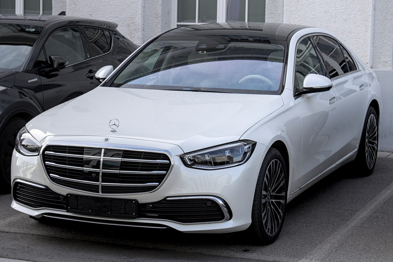 Front view of a white luxury sedan with chrome grille and LED headlights