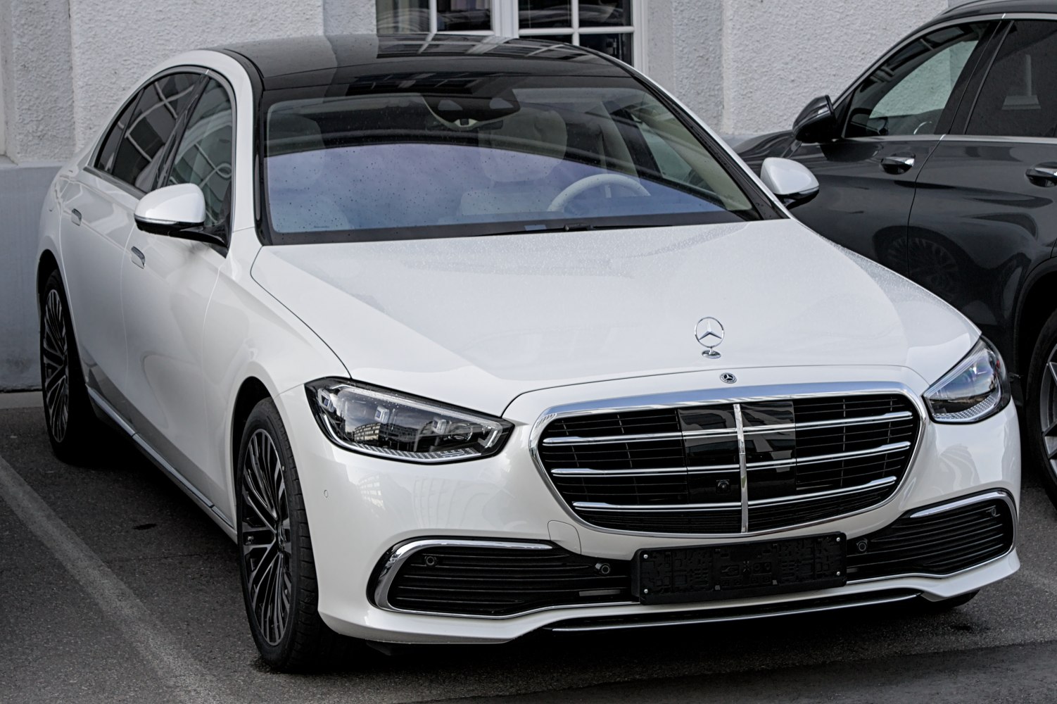 White luxury sedan with prominent grille and LED headlights