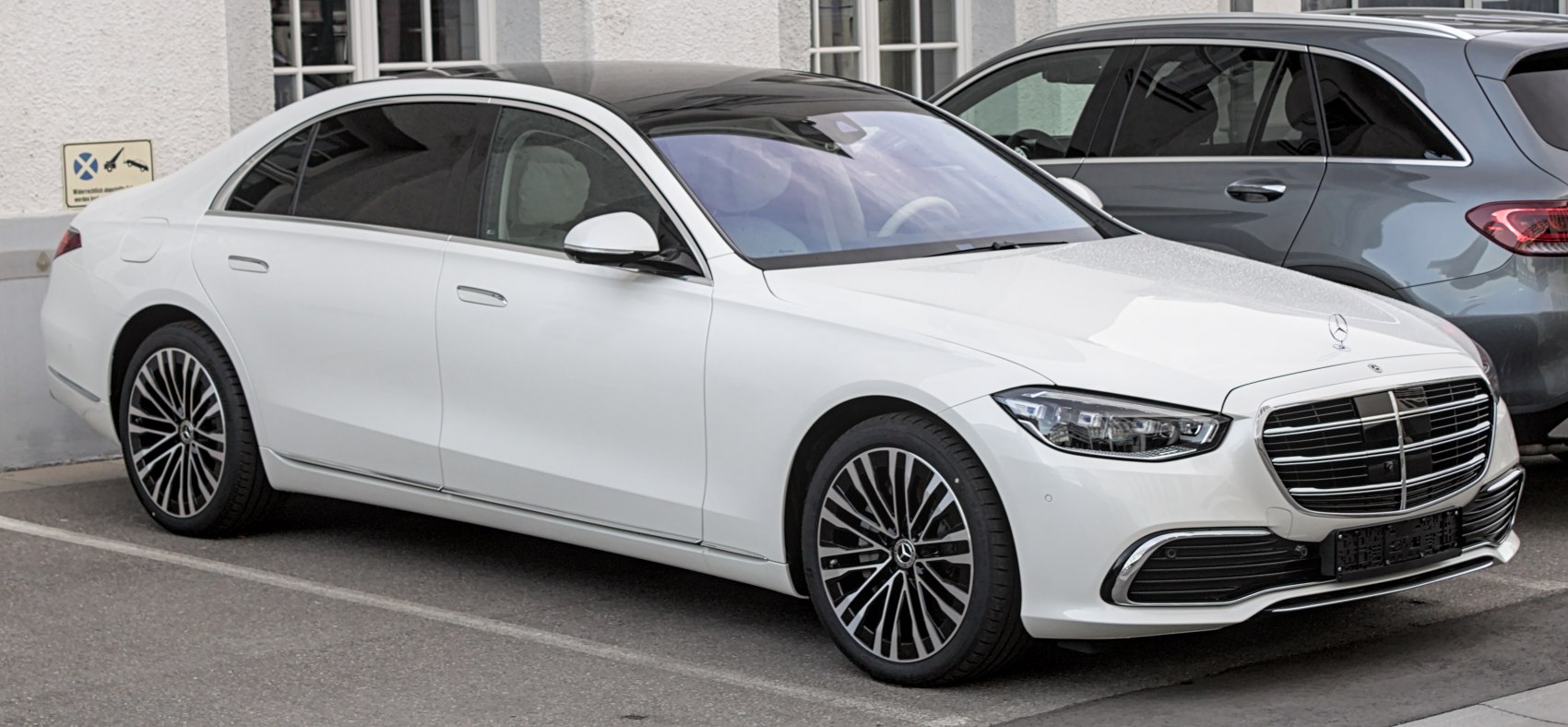 Luxury sedan front side view with distinctive grille and multi-spoke alloy wheels