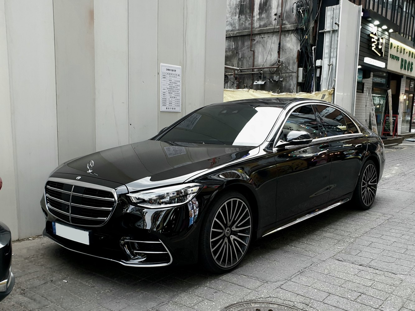 Luxury sedan front three-quarter with prominent grille and alloy wheels