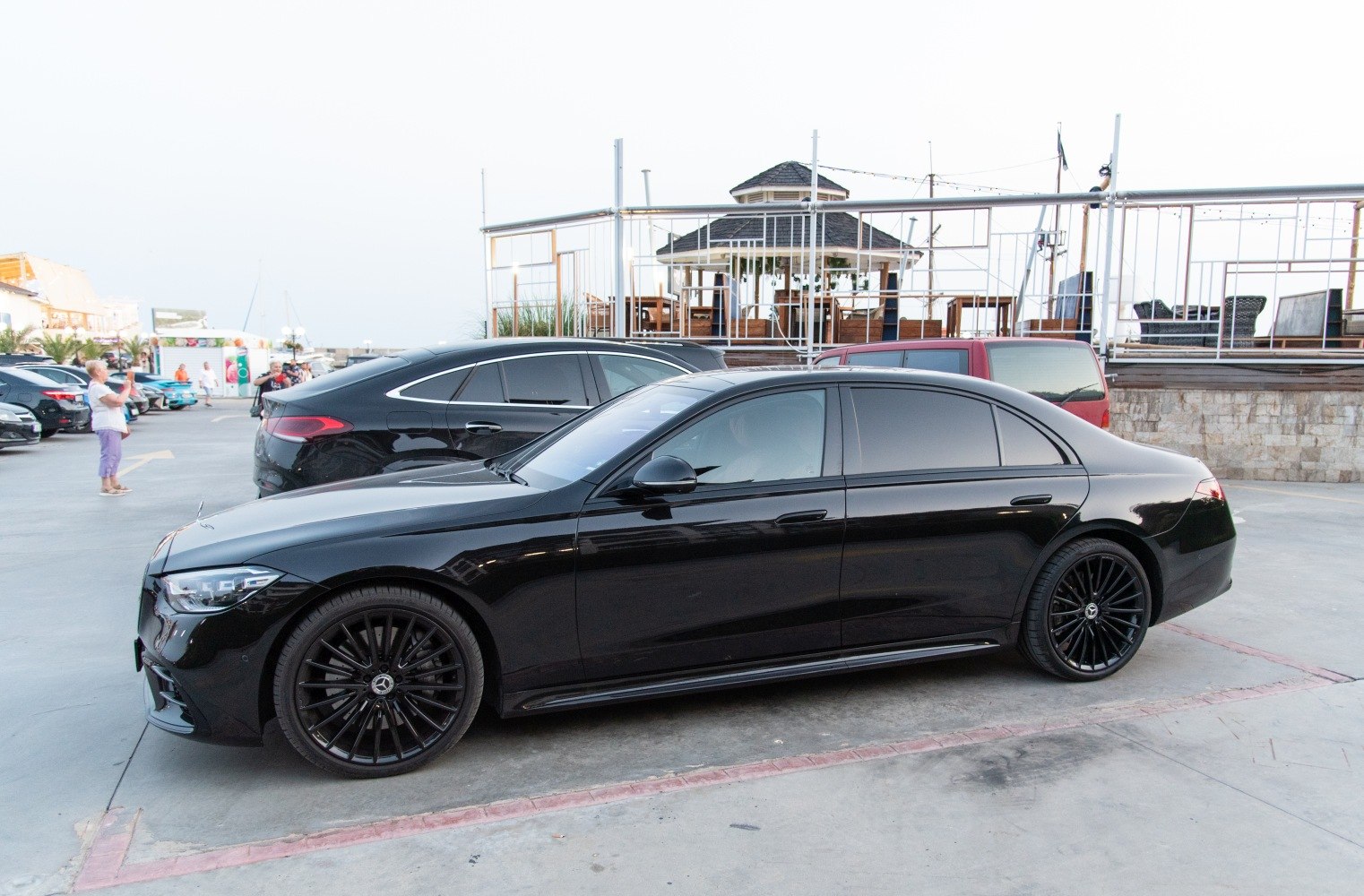 Sleek black luxury sedan with tinted windows and multi-spoke alloy wheels.