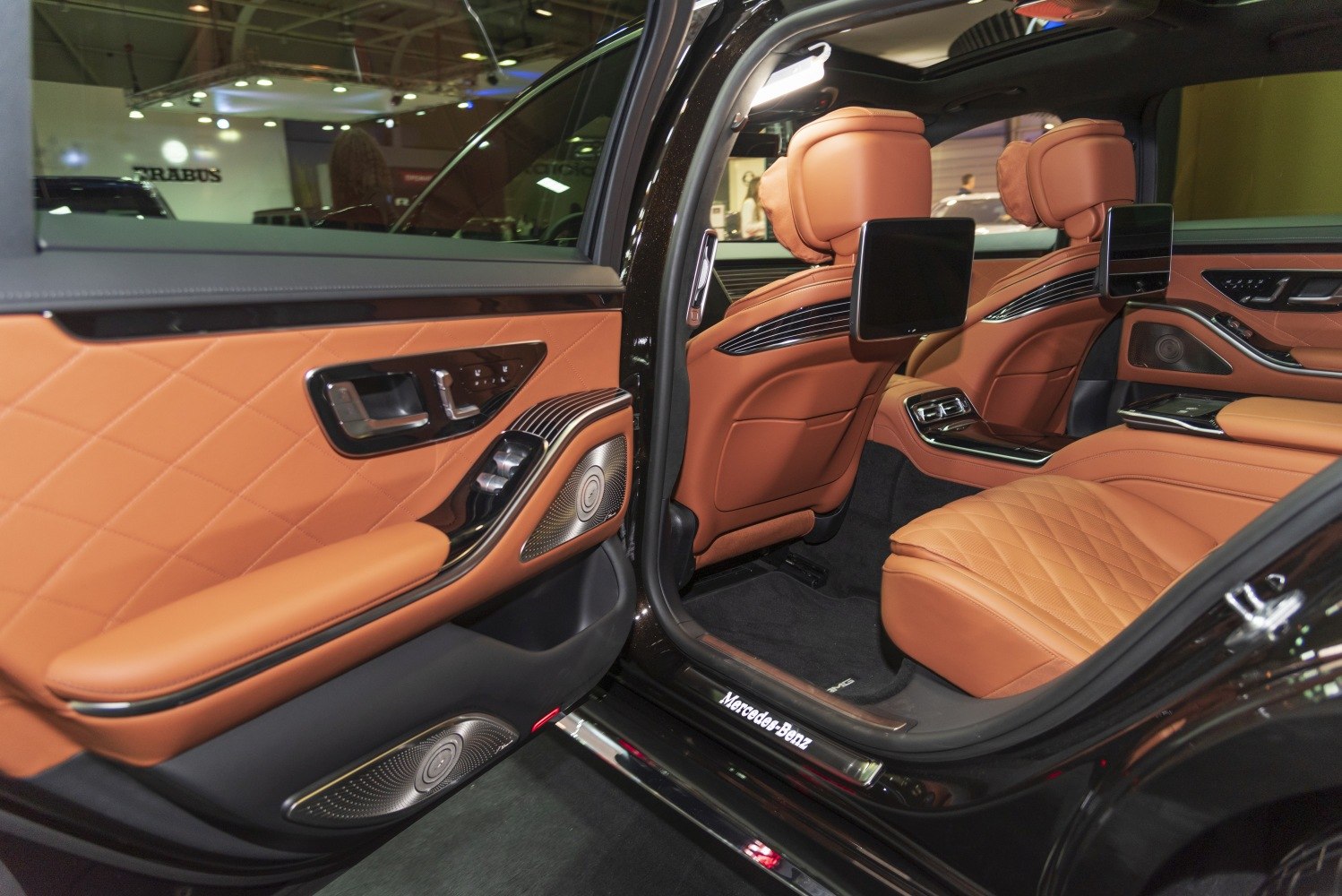 Tan leather rear seats with seatback screens and premium audio speakers