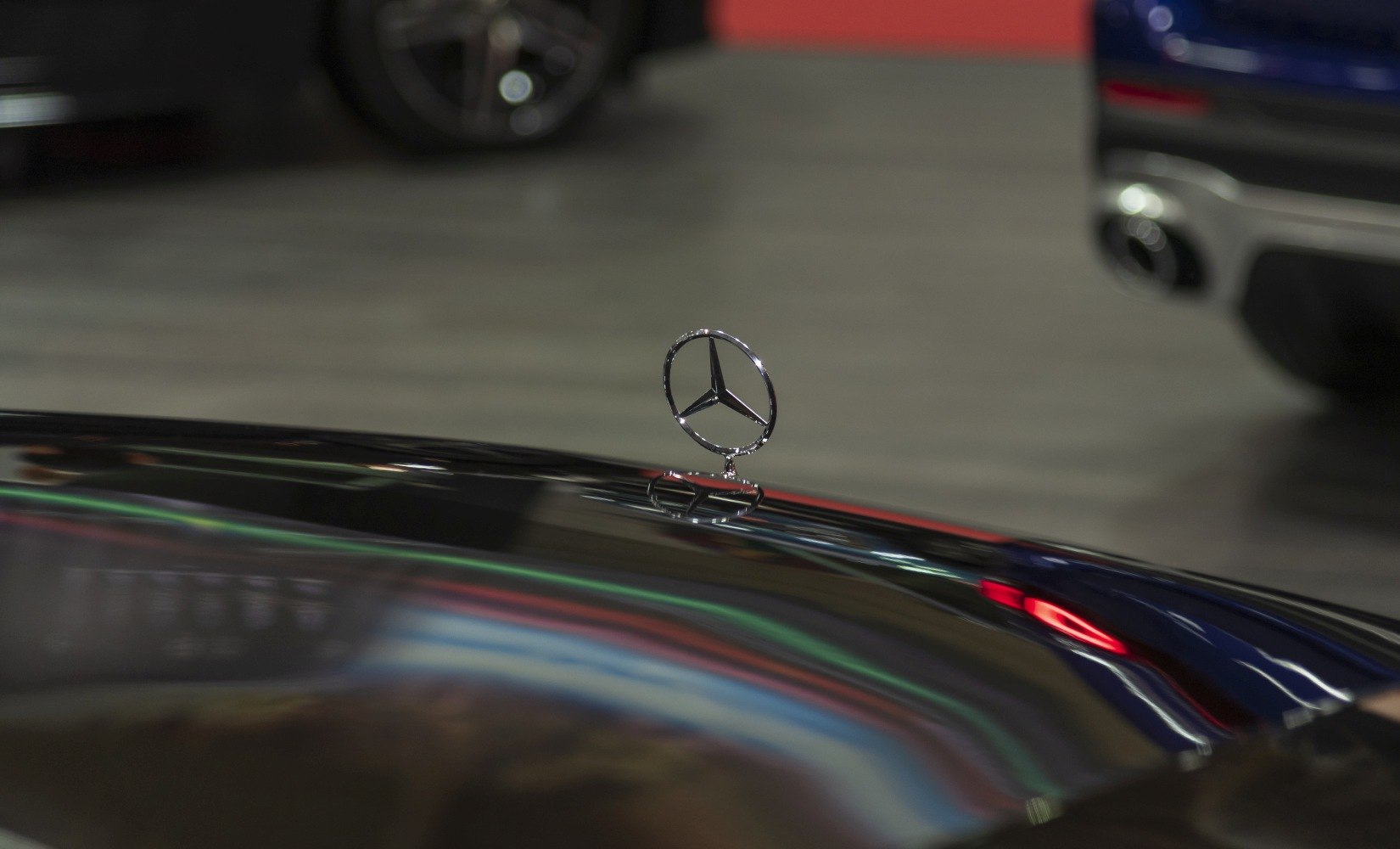 Close-up of a chrome Mercedes-Benz hood ornament on a car hood