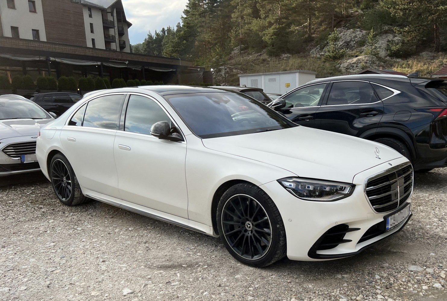 White luxury sedan with black alloy wheels and LED headlights