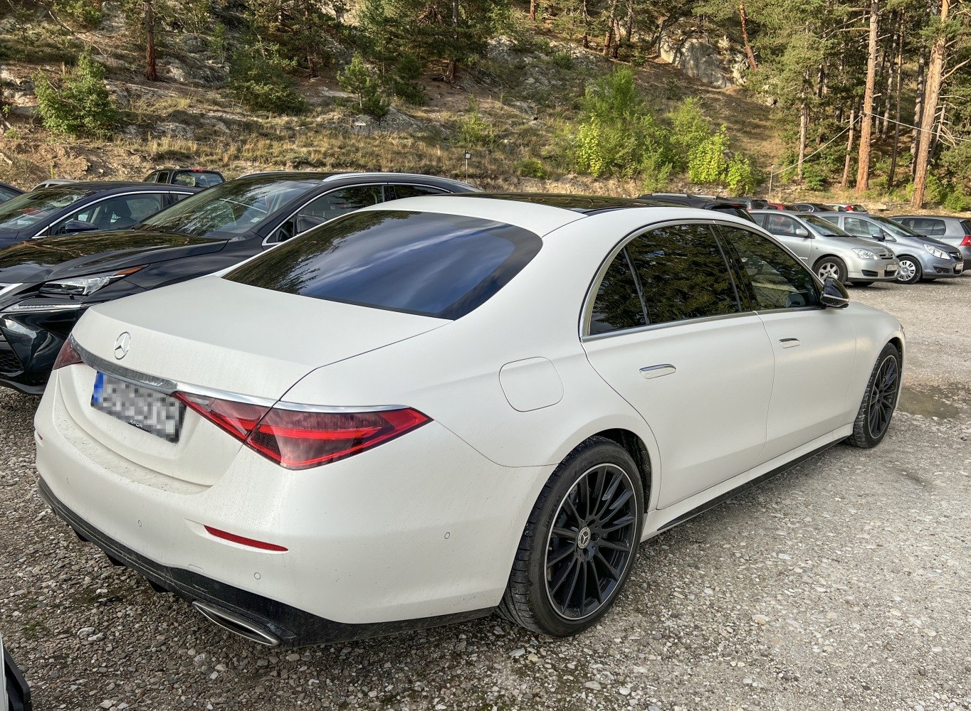 Luxury sedan rear view with distinctive tail lights and black multi-spoke wheels