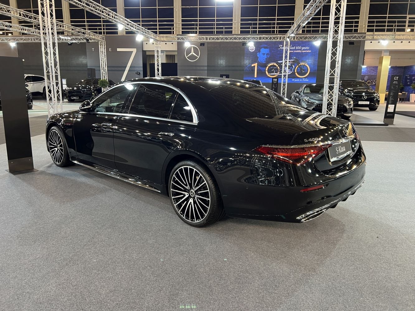 Luxury black sedan with sporty multi-spoke alloy wheels and elegant rear design.