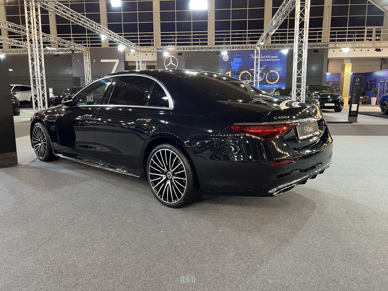 Luxury sedan rear-side, LED taillights, stylish multi-spoke alloy wheels