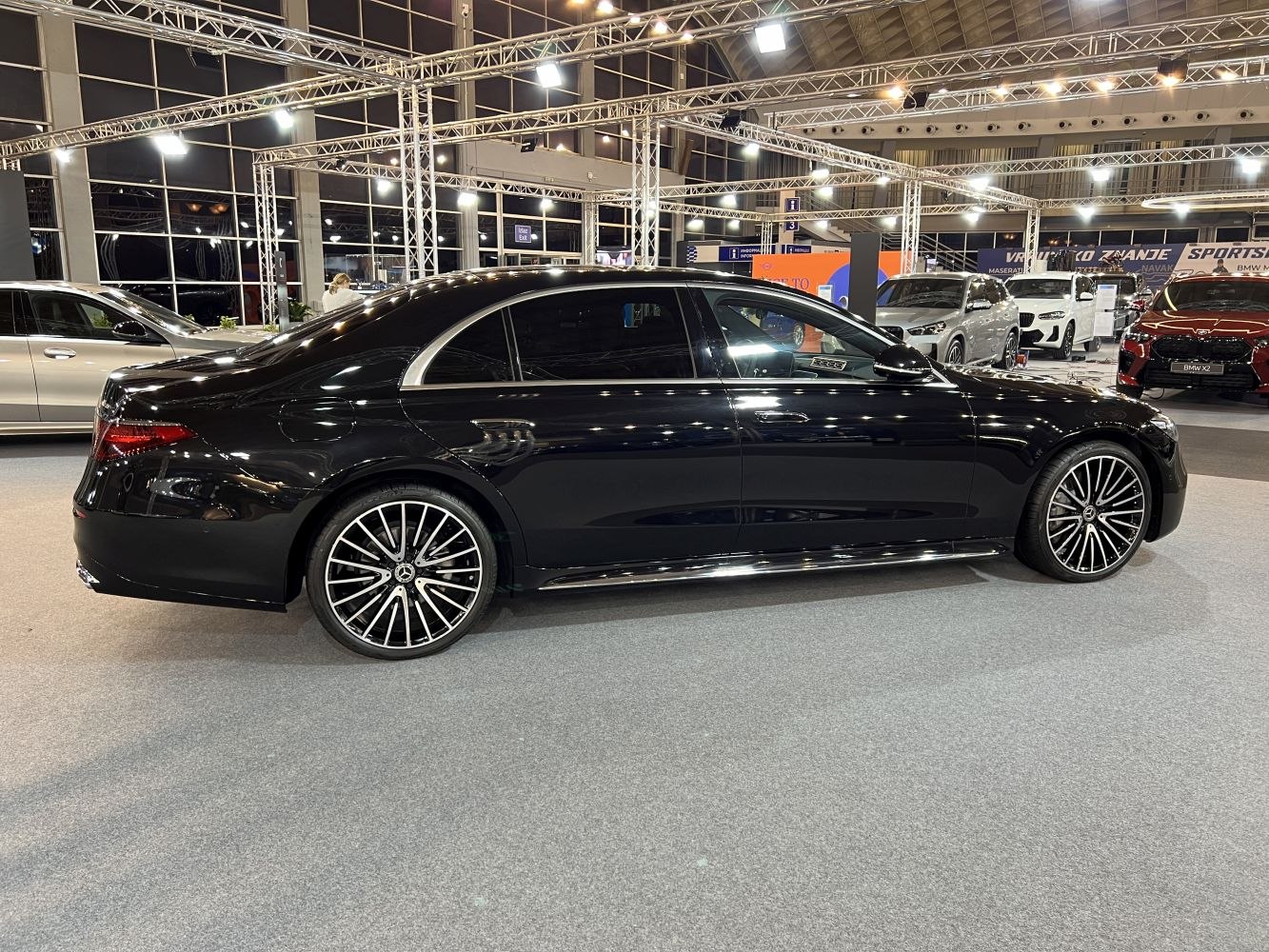 Black luxury sedan side view with multi-spoke alloy wheels