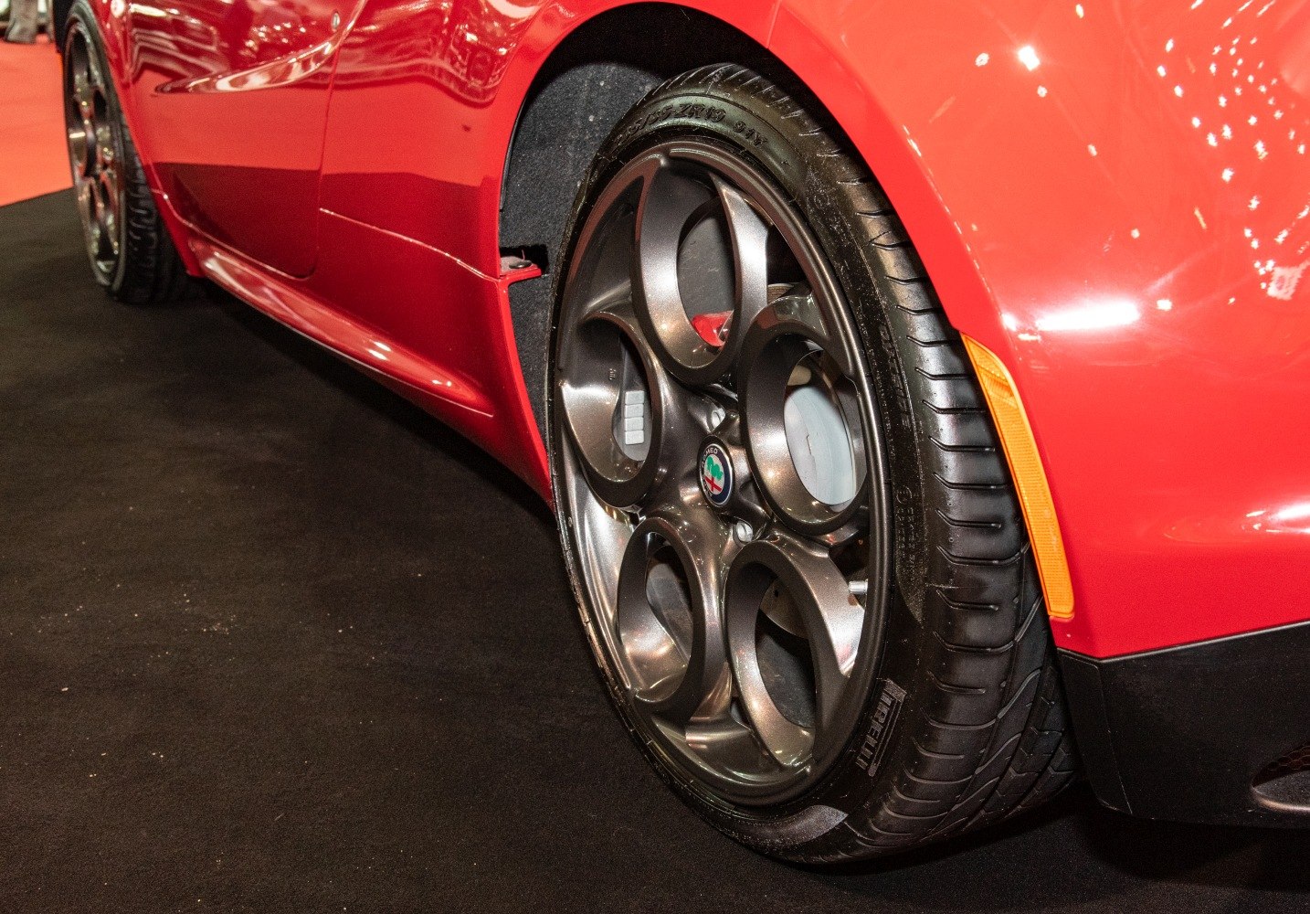 Close-up of alloy wheel and side skirt on red sports car