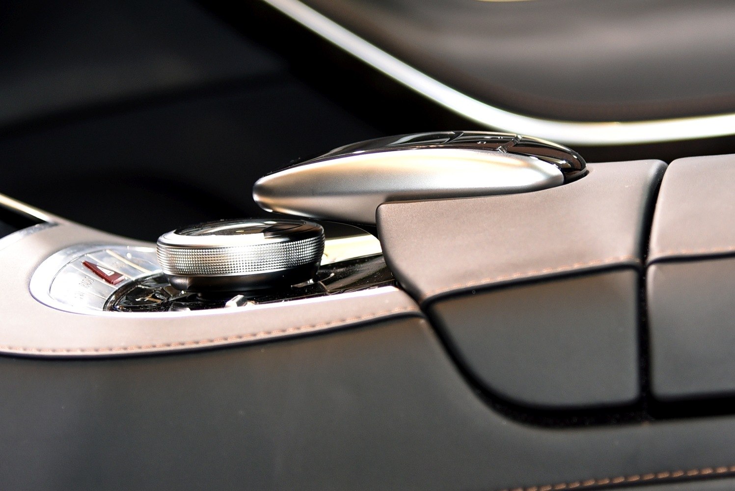 Close-up of central control knob and leather armrest