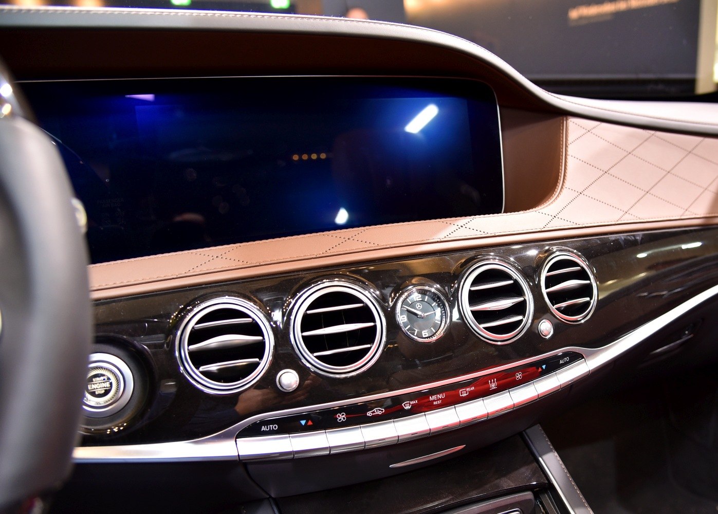Dashboard with circular air vents and analog clock in leather-trimmed interior