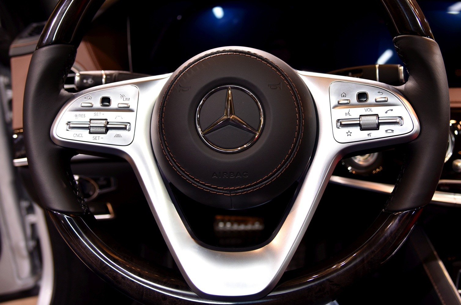 Luxury steering wheel with multifunction control buttons and emblem