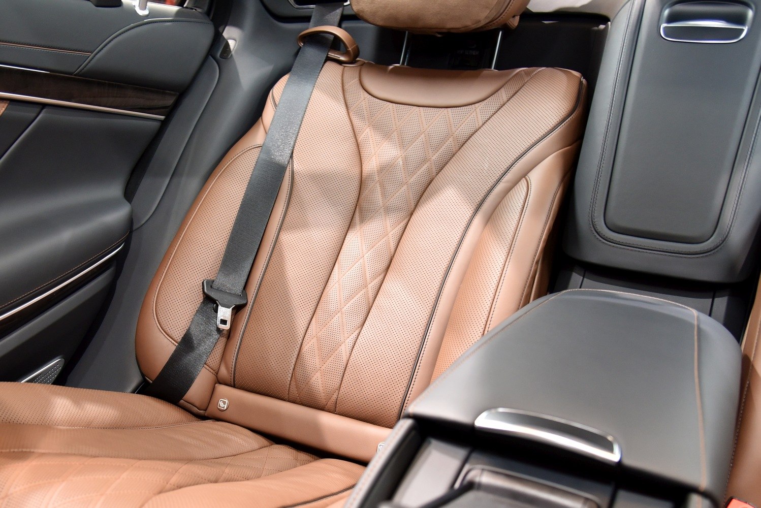 Brown perforated leather rear seat with black seatbelt and center console