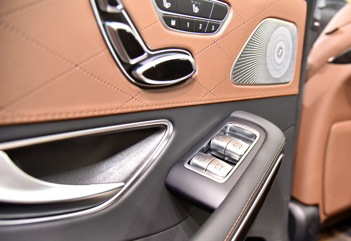 Interior door panel with window controls, seat adjustment buttons, premium speaker
