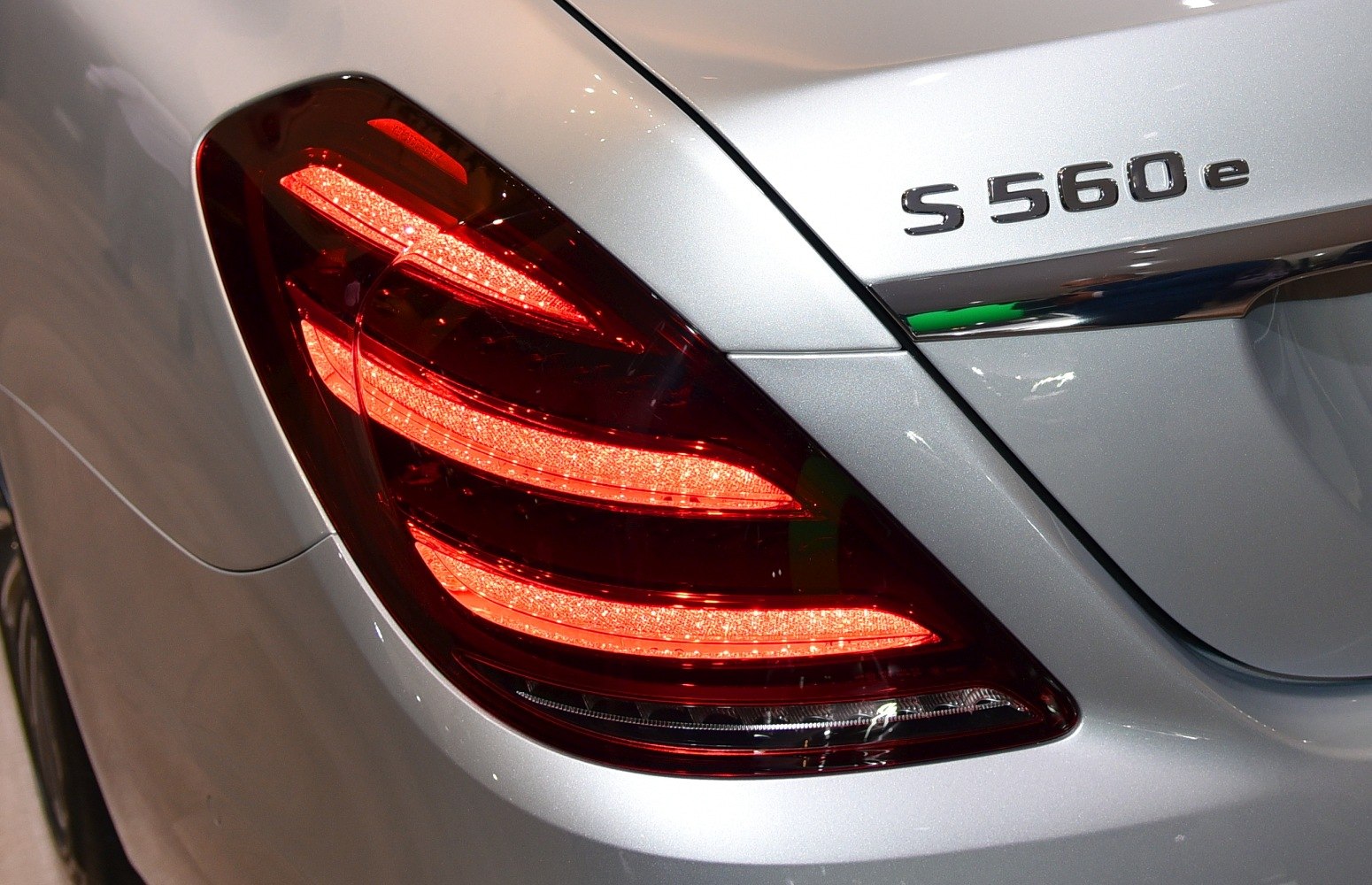 Rear LED taillight and S 560 e badge on silver luxury sedan