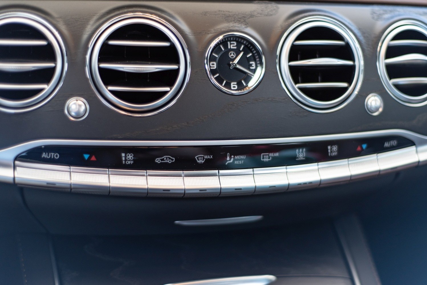 Luxury car interior with circular air vents and an analog clock