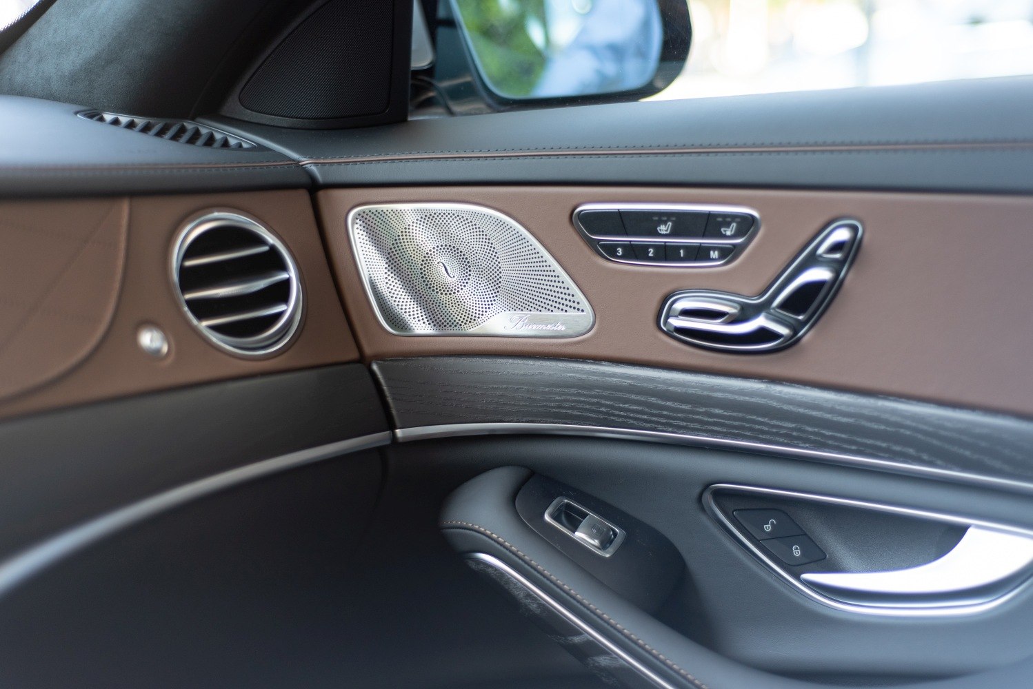 Car door interior with Burmester speaker and seat adjustment controls