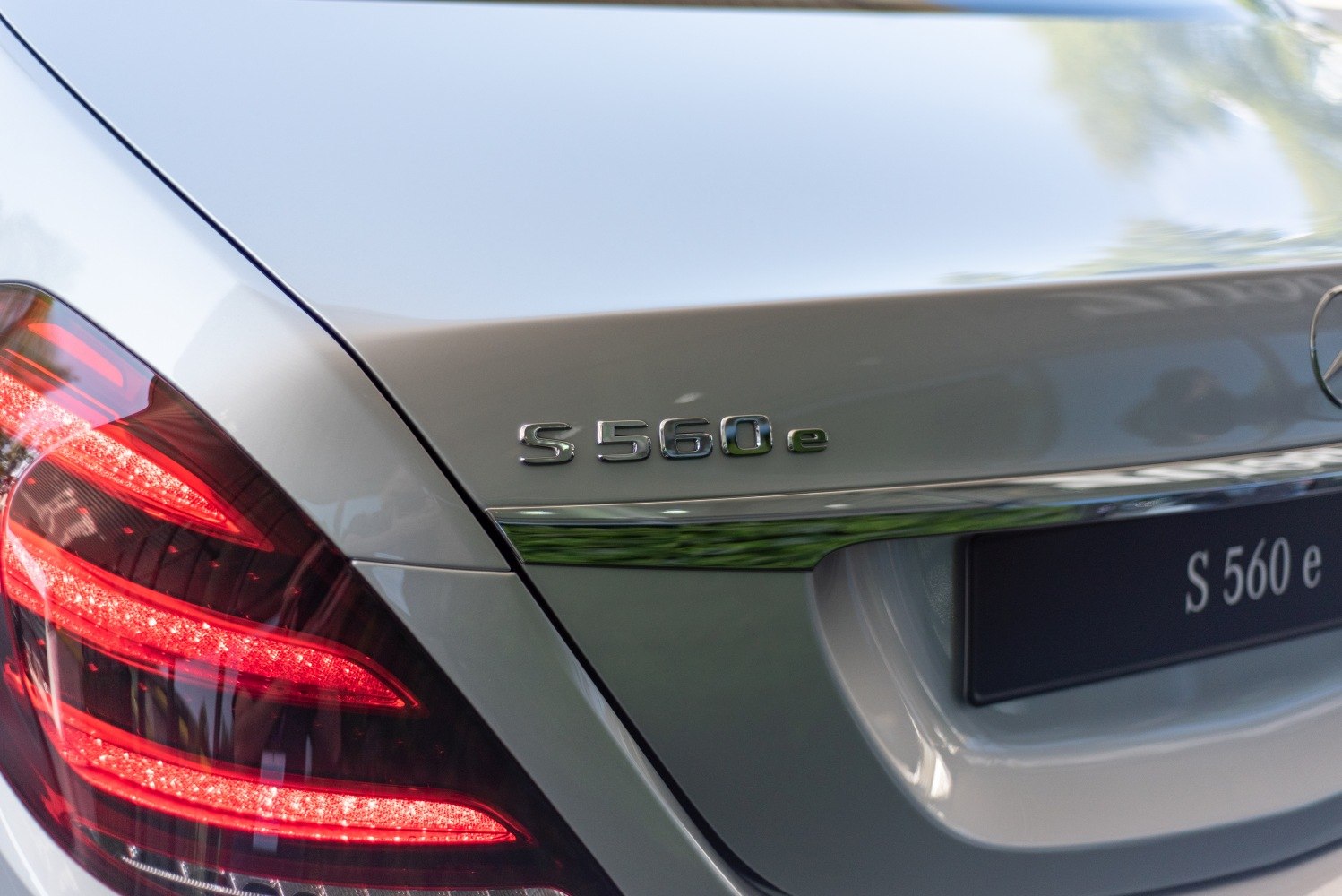 Close-up of S 560 e badge and illuminated rear taillight
