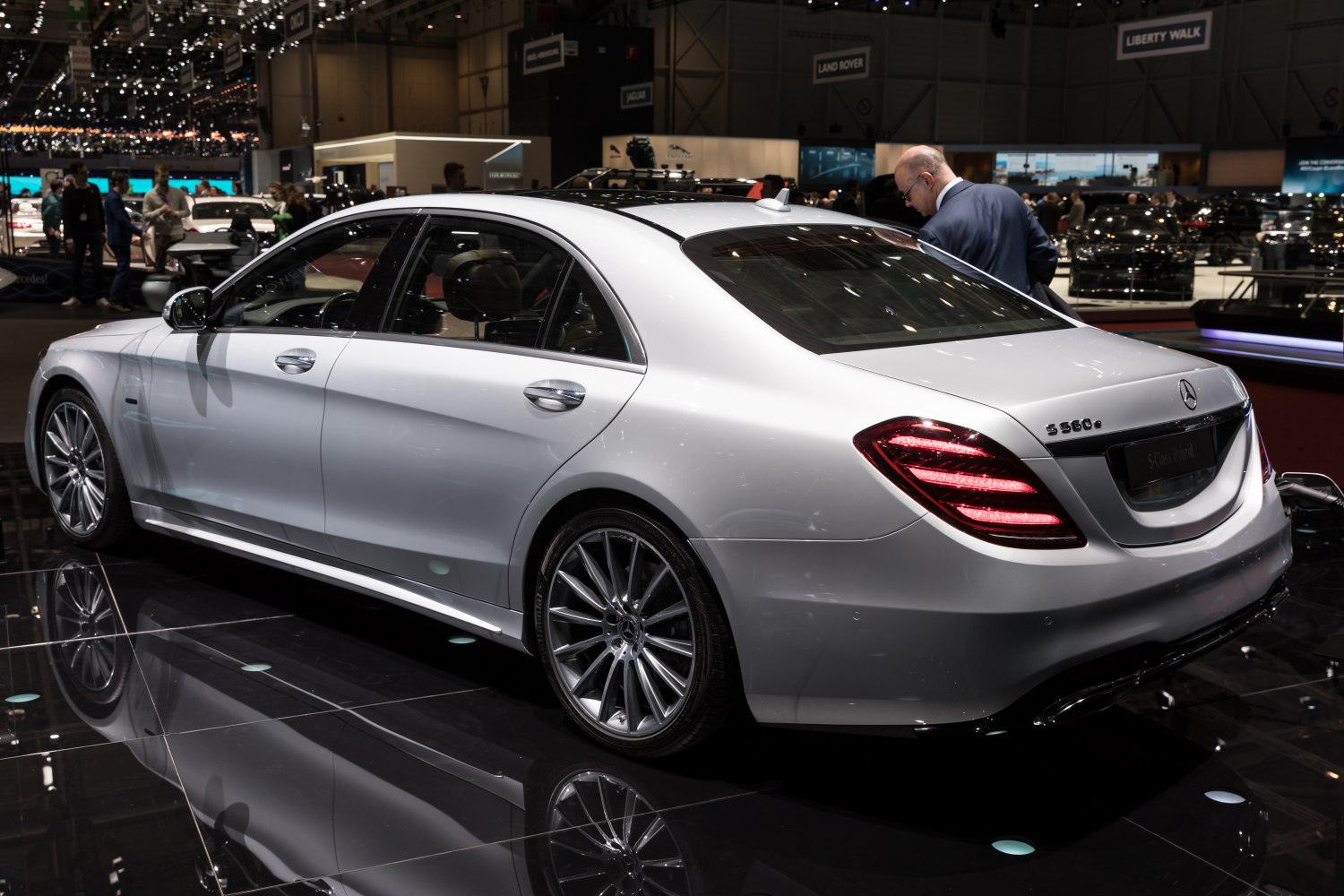 Silver full-size sedan rear side with LED tail lights and multi-spoke wheels