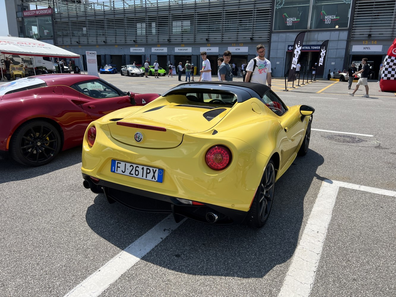 Yellow convertible sports car rear with round taillights and dual exhaust