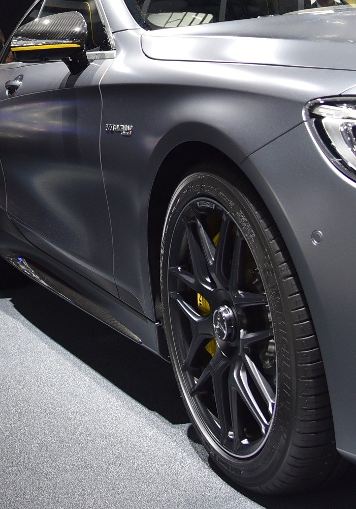 Close-up of AMG wheel, matte paint, and carbon fiber mirror cap on luxury coupe