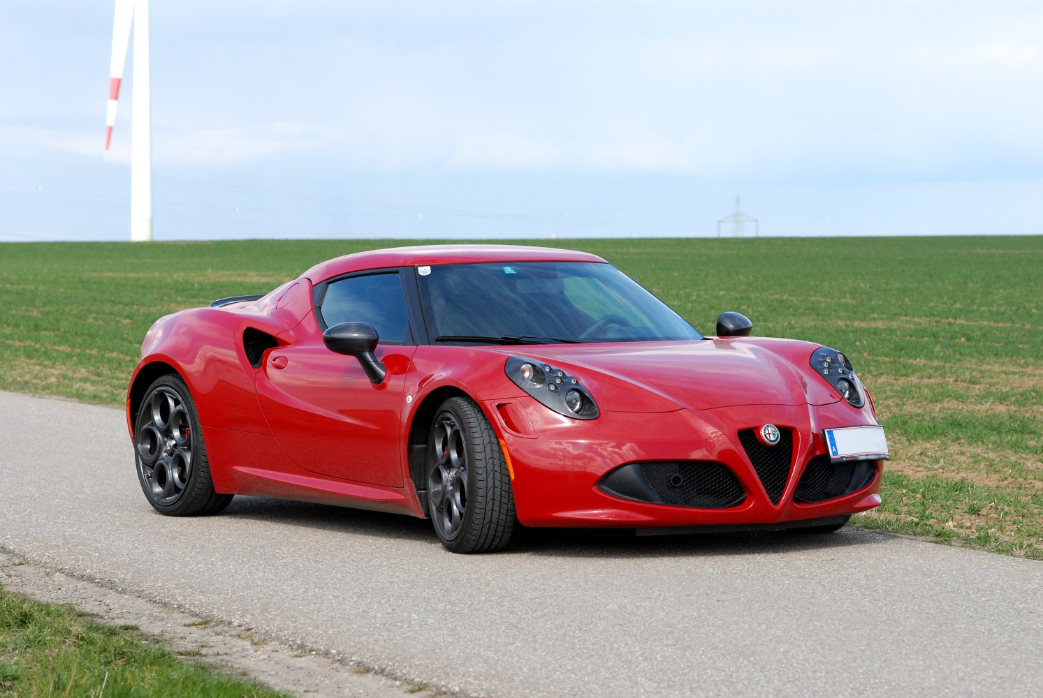 Red mid-engine sports coupe with distinctive headlights and side air vents