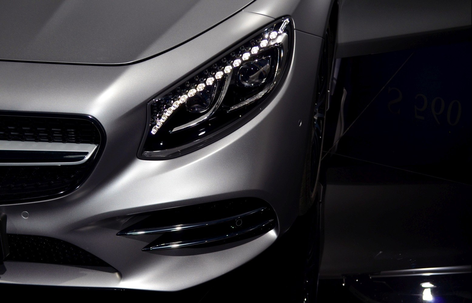 Close-up of front LED headlight and grille section