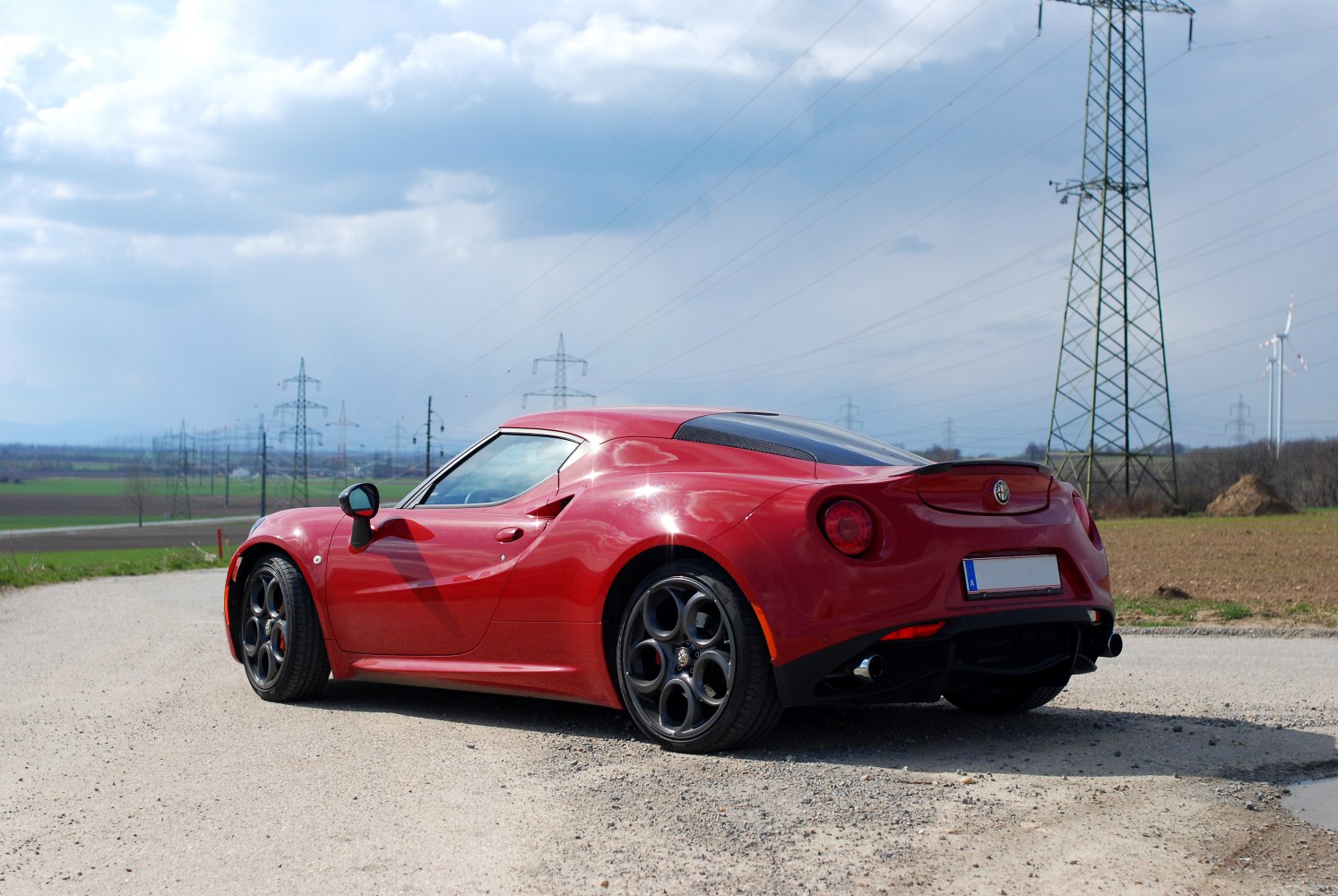 Rear side view of red sports coupe with alloy wheels