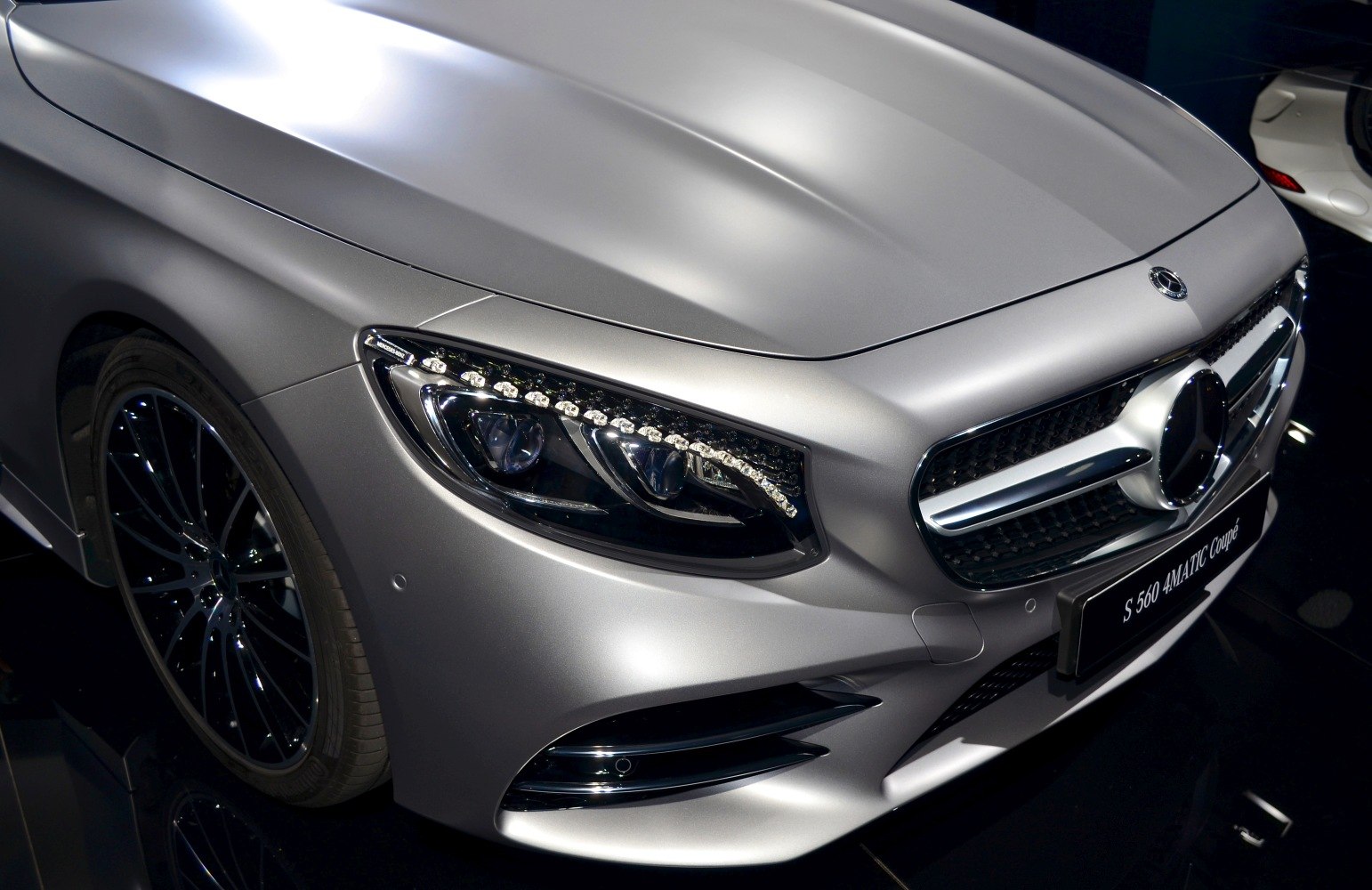 Front headlight and grille of a luxury coupe.