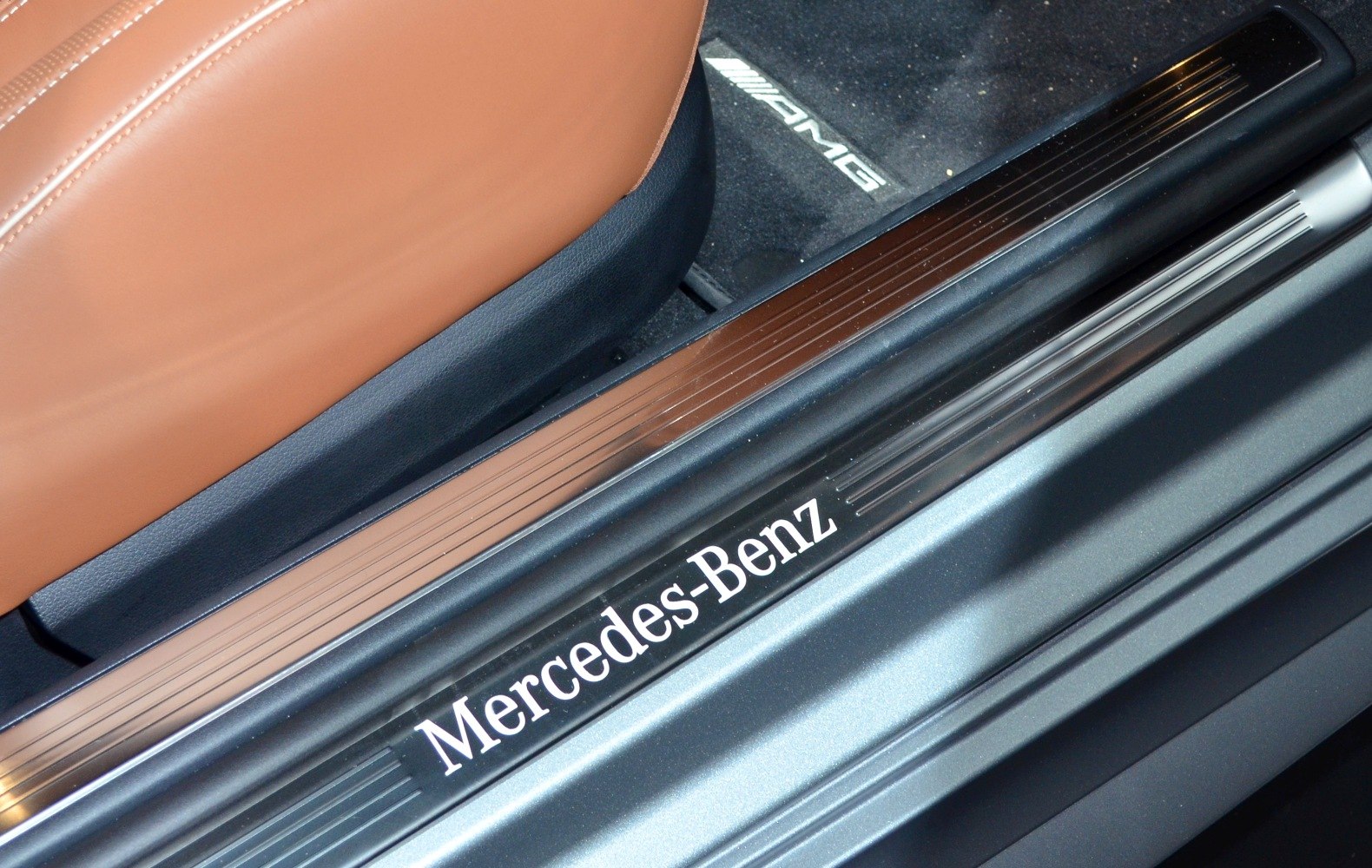 Luxury car door sill with Mercedes-Benz logo and AMG floor mat