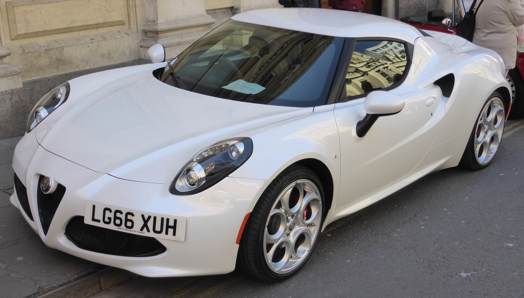 White sports coupe front side profile with distinctive headlights and alloy wheels