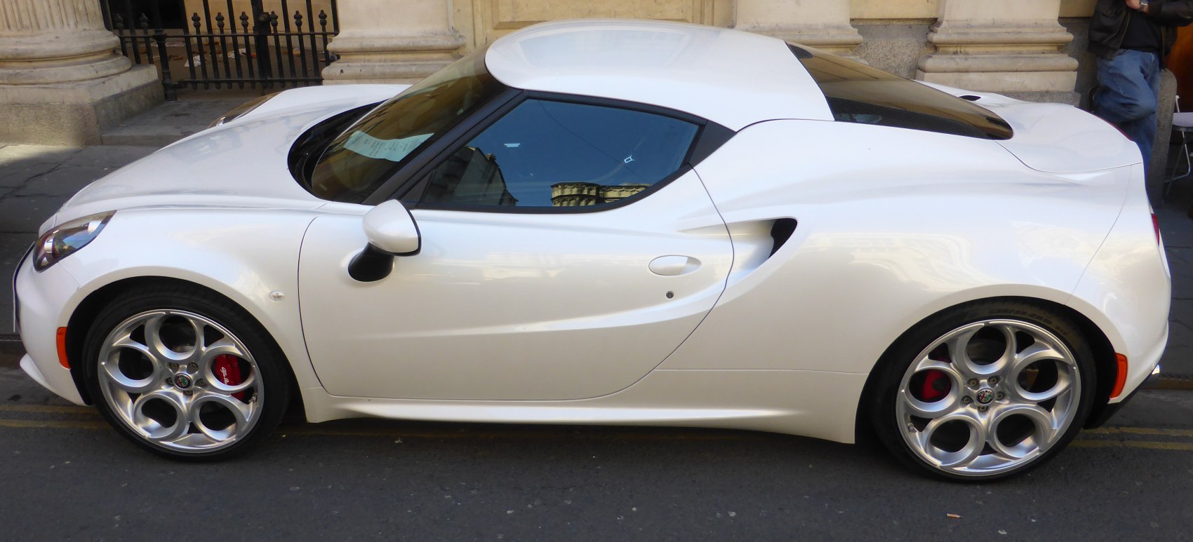 Side profile of a compact sports coupe with distinctive circular alloy wheels.