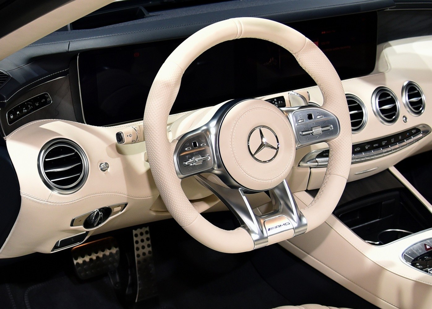 Beige leather steering wheel and dashboard of luxury car interior