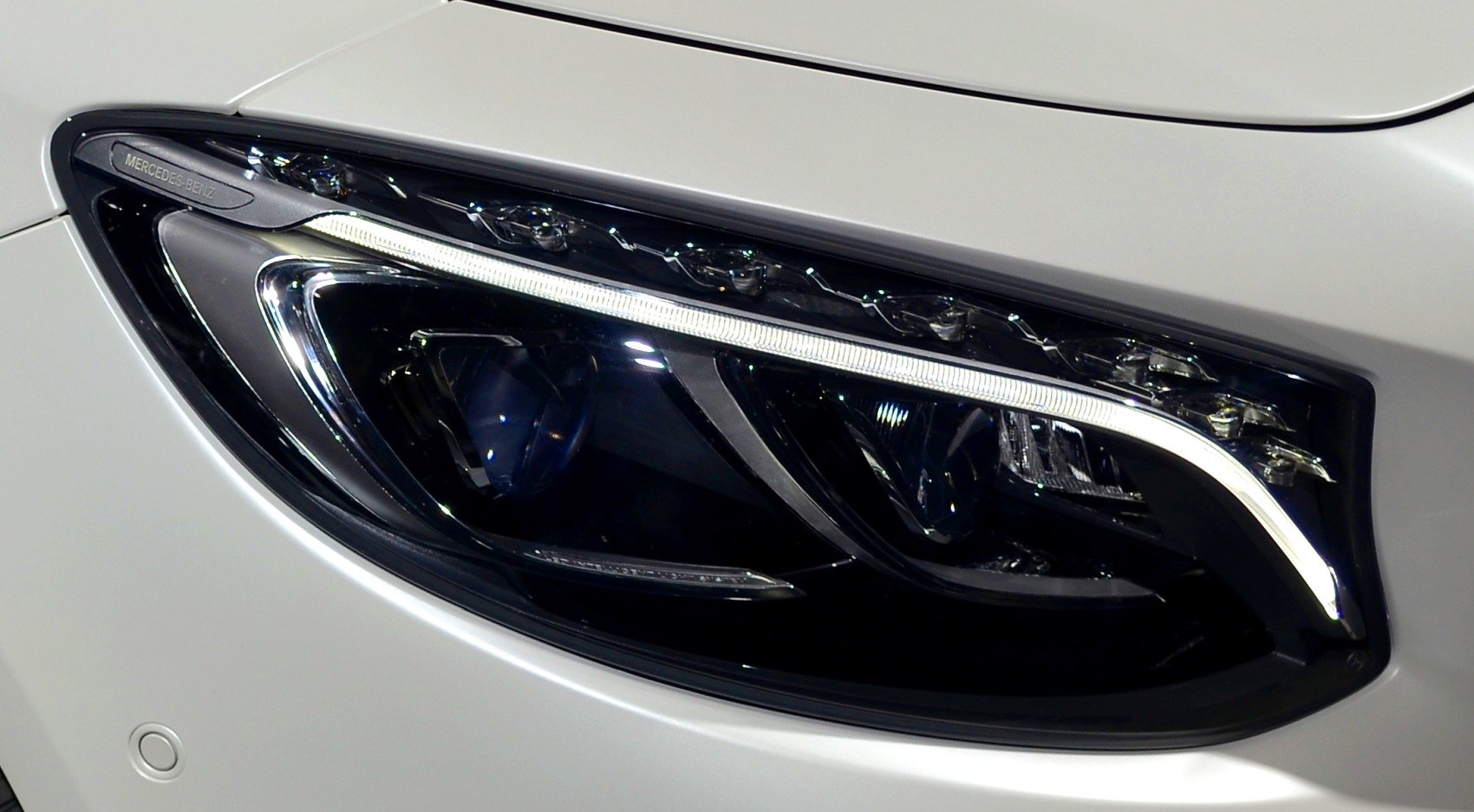 Close-up of a luxury car LED front headlight with signature design elements.