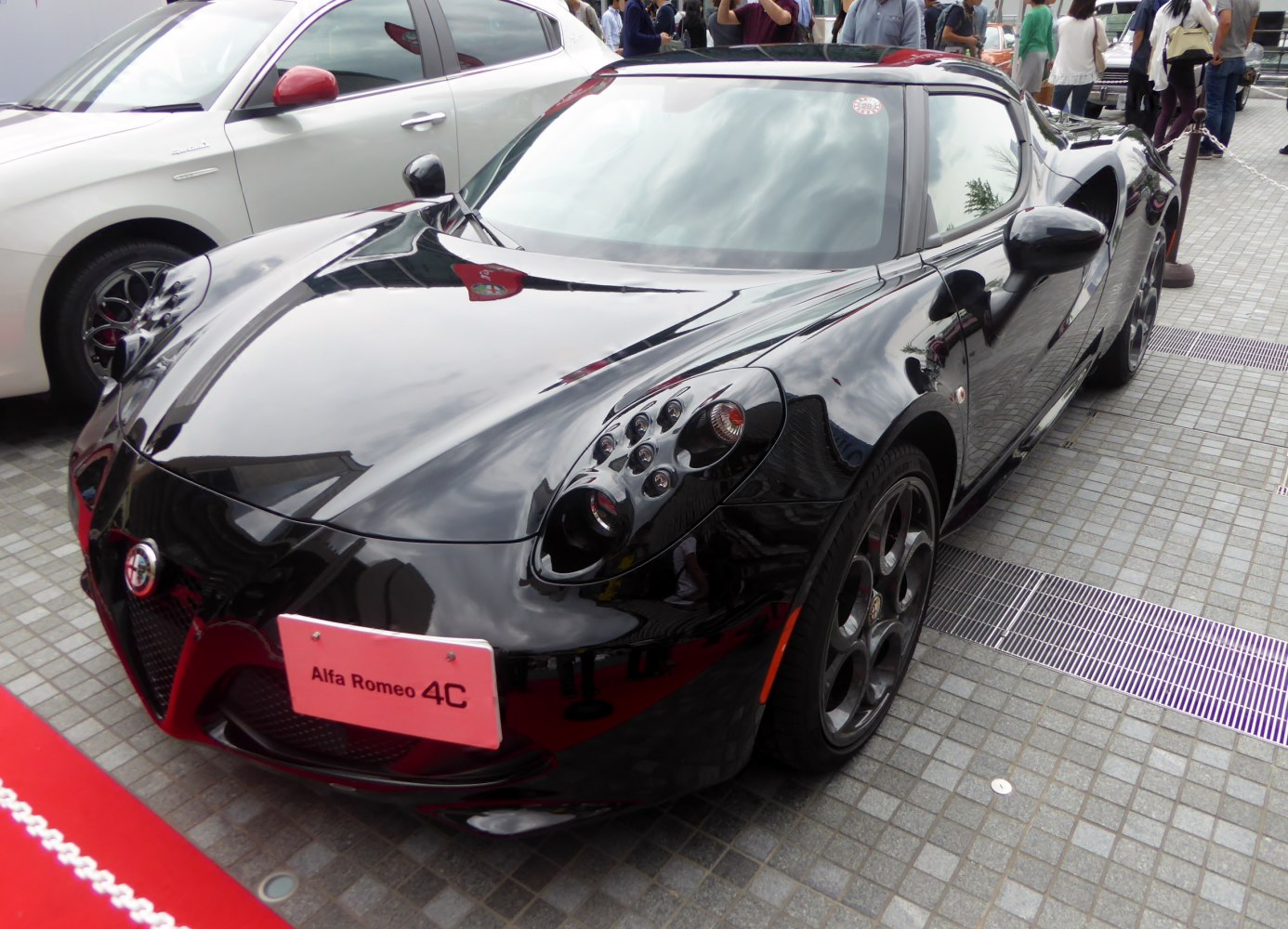 Glossy black sports car with distinctive multi-element headlights