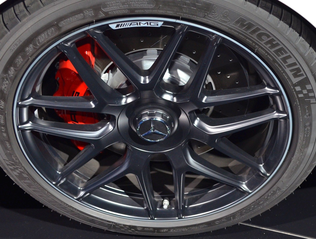 Black AMG multi-spoke alloy wheel with red brake caliper and drilled brake disc