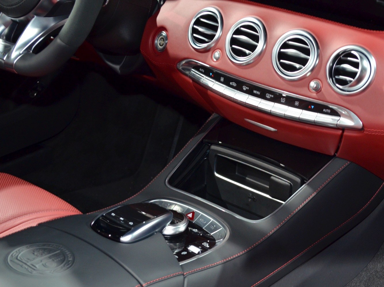 Red leather dashboard with circular air vents and refined center console controls.