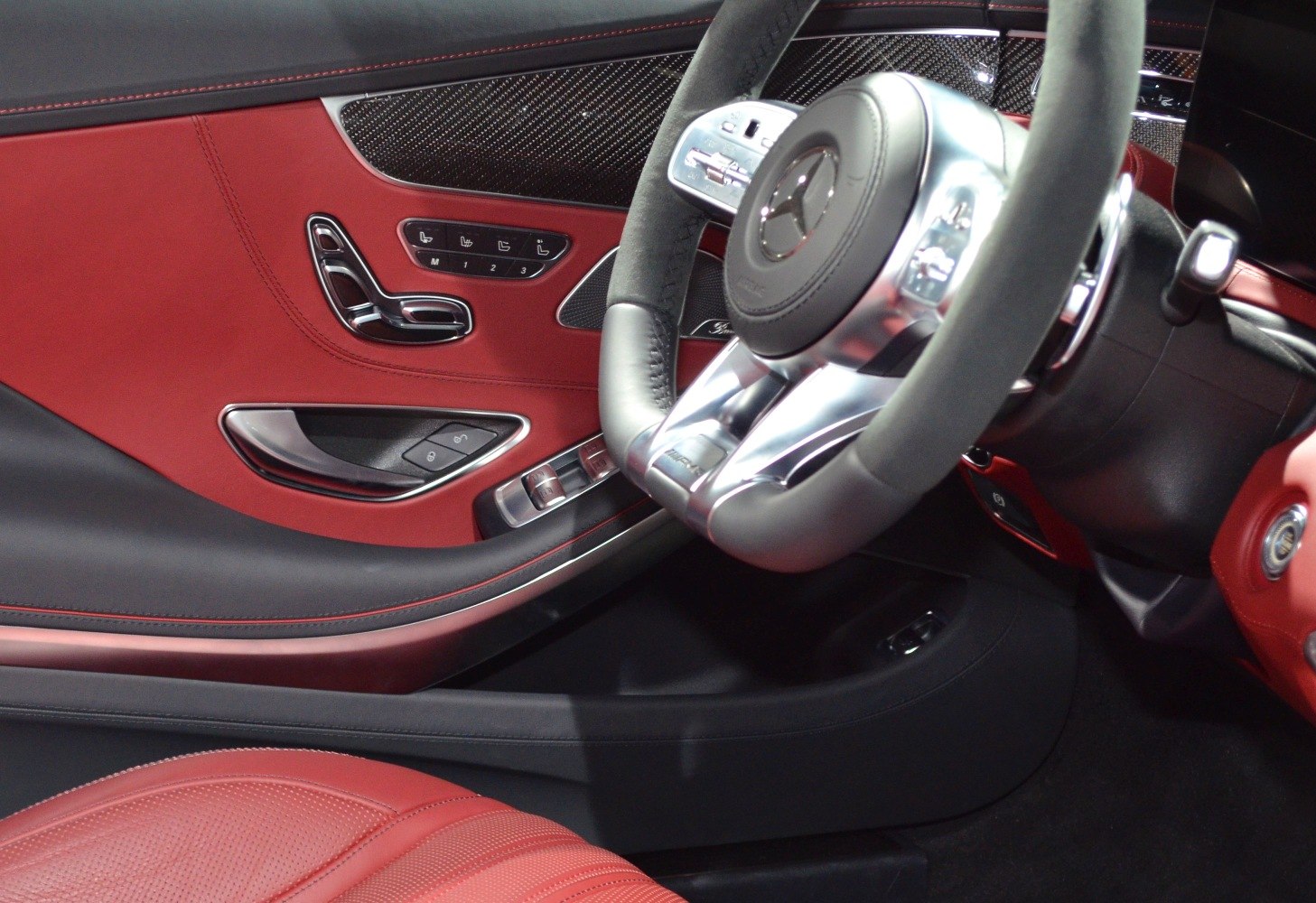 Red leather door panel and sporty steering wheel with controls