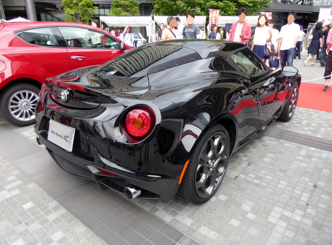 Rear view of black sports coupe with round taillights and dual exhaust pipes