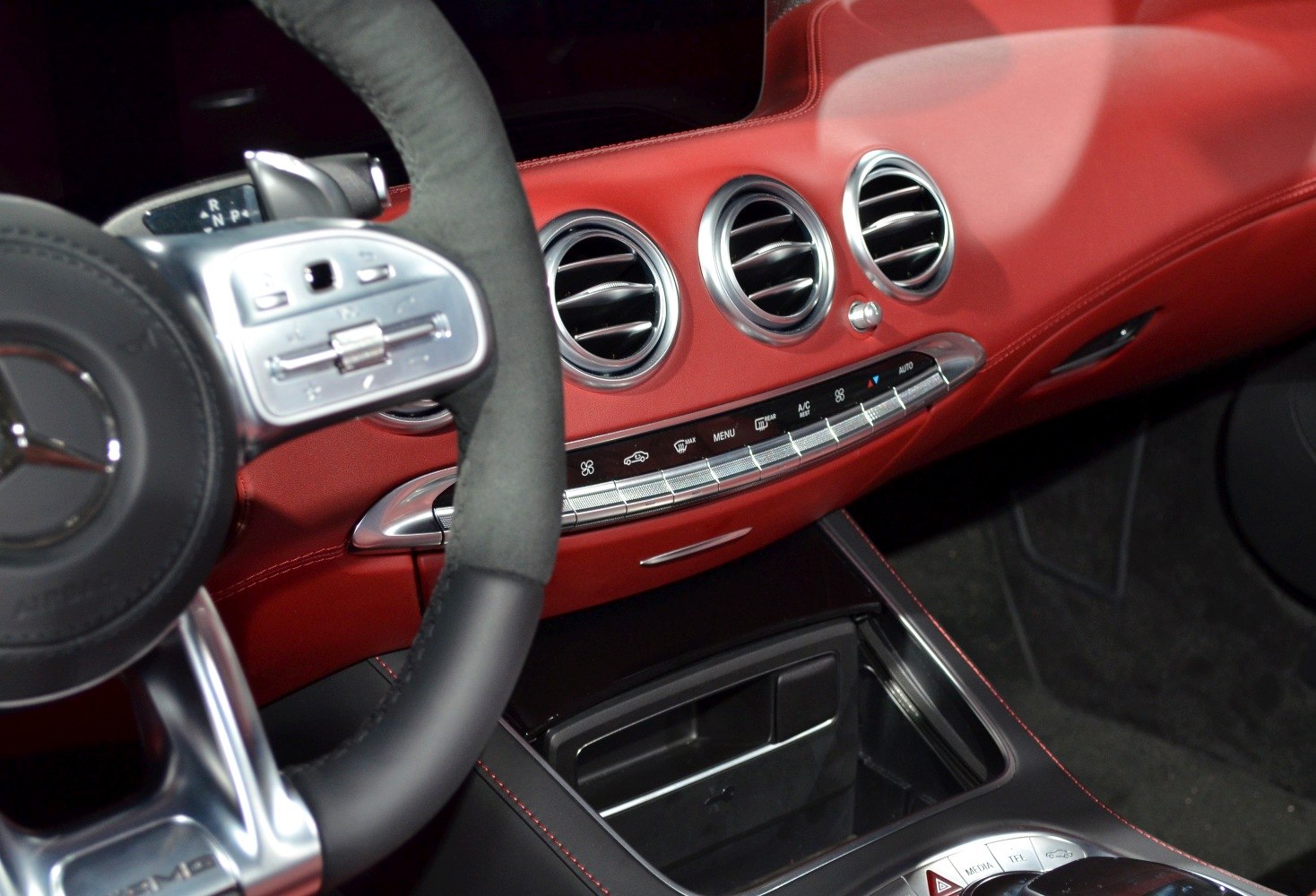 Red leather dashboard with round air vents and steering wheel controls