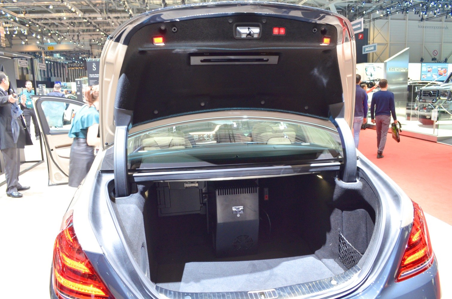 Spacious luxury sedan trunk with built-in electronic unit and lighting.
